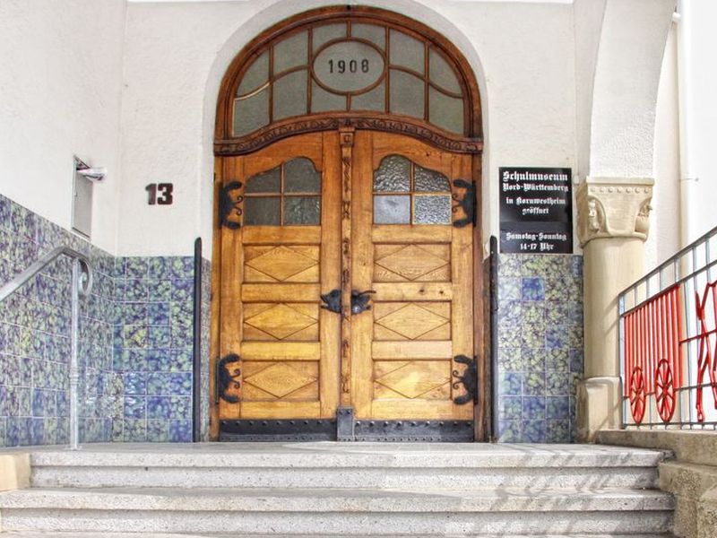 Eingang mit Baujahr "1908" über der geschlossenen zweiflügeligen Tür.